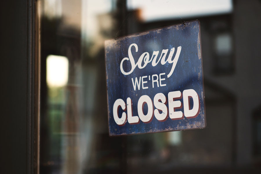 A closed sign hangs in the window of a business.